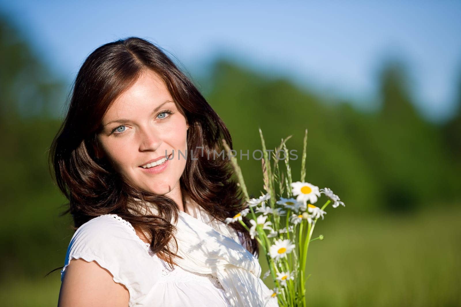 Beautiful woman with flowers on sunny day