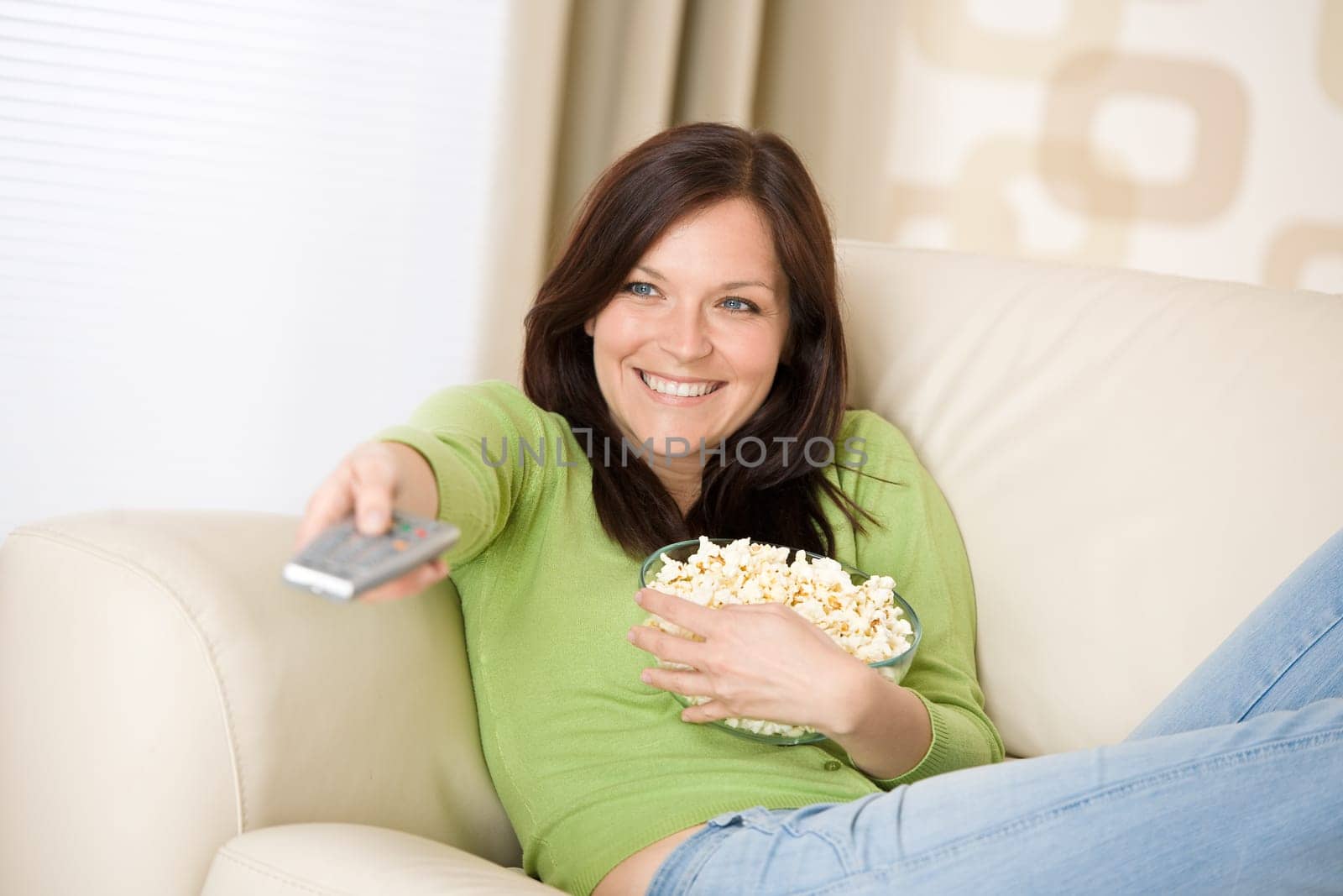 Woman watching television with popcorn in living room
