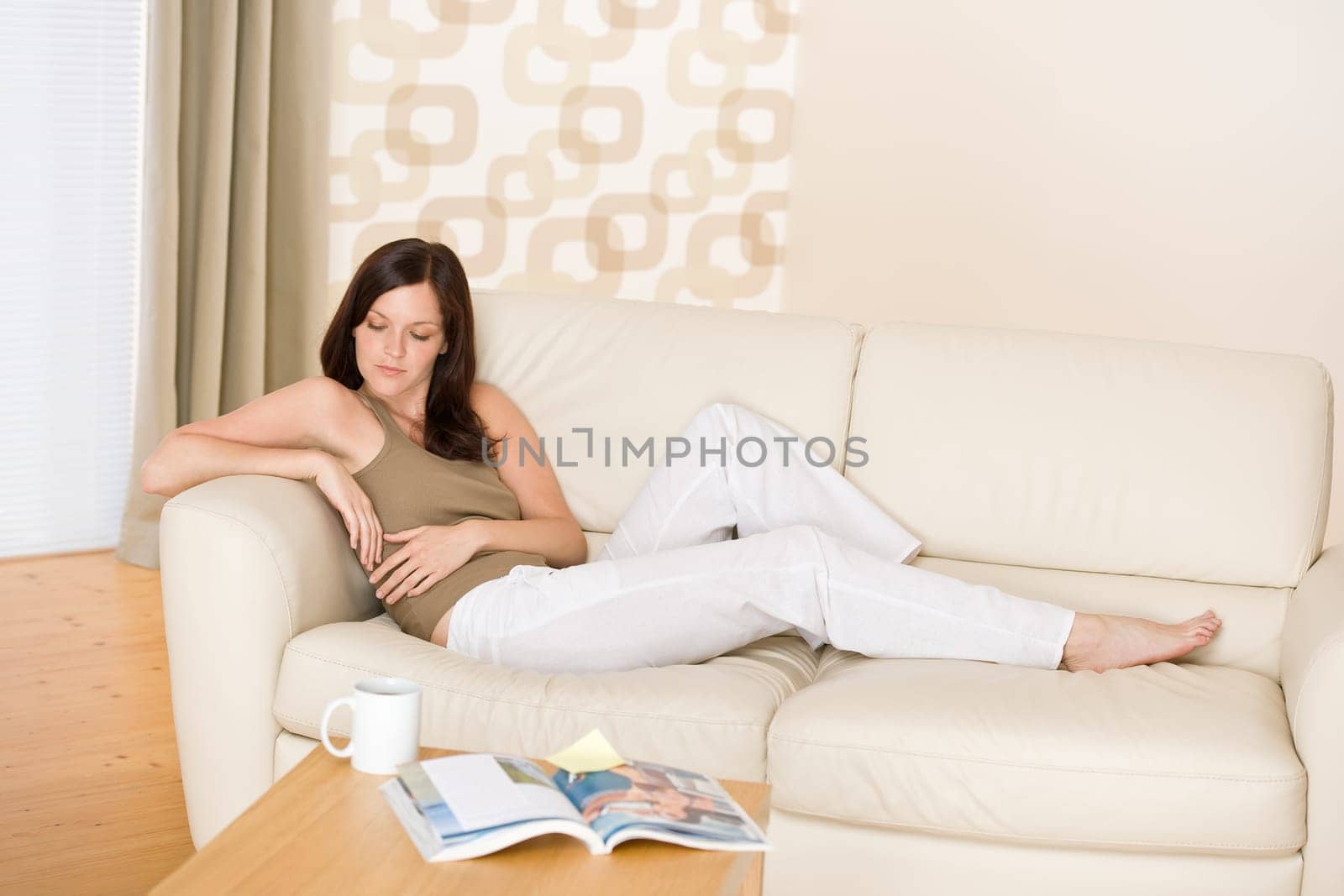Young woman with magazine and coffee in lounge