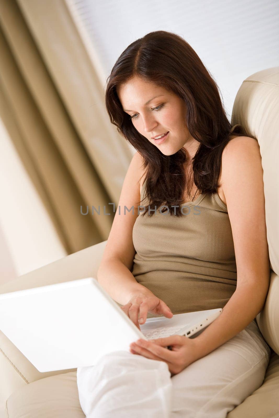 Young woman with laptop on sofa home in living room