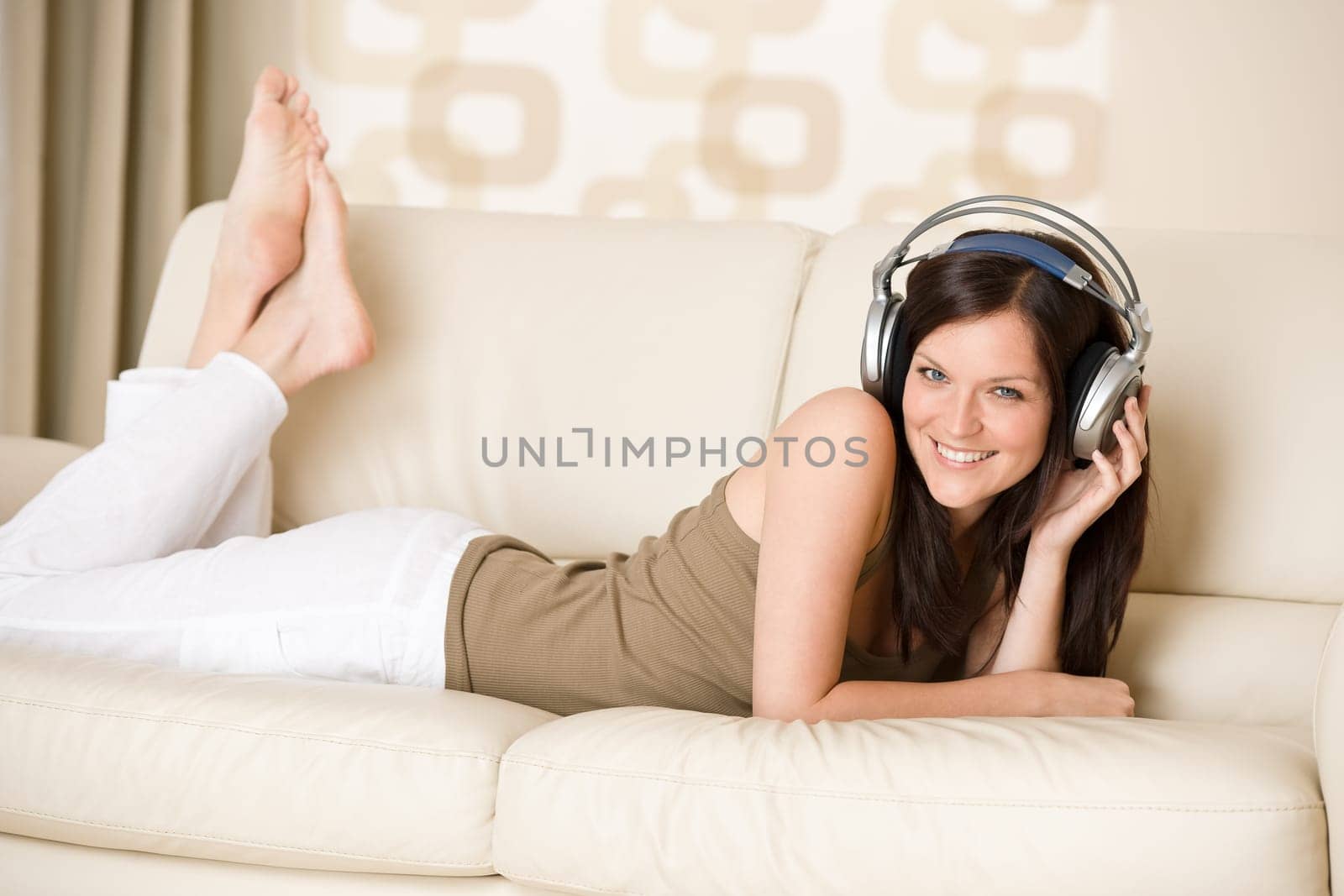 Smiling woman with headphones  listen to music in lounge
