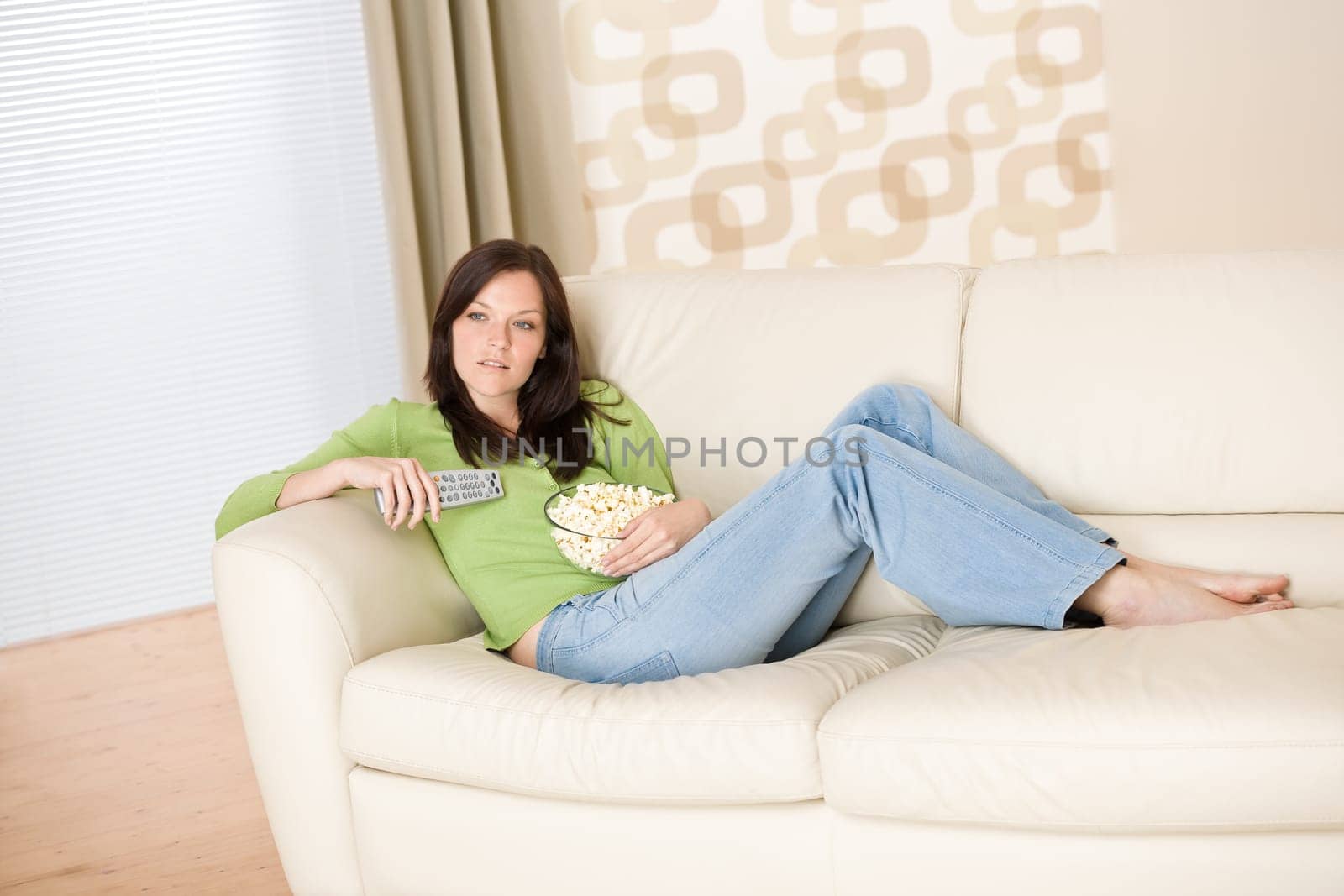 Woman watching television with popcorn in living room
