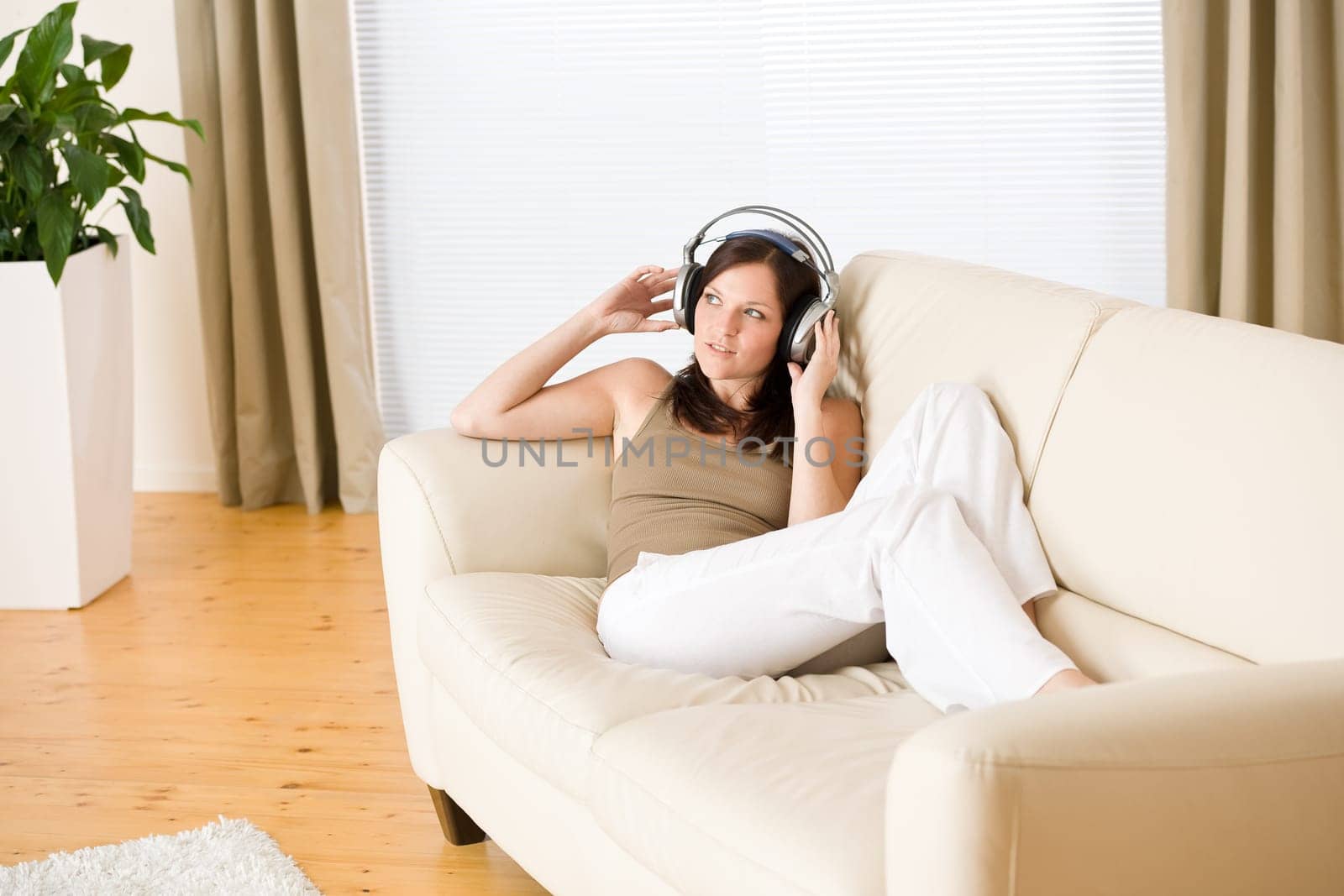 Smiling woman with headphones  listen to music in lounge