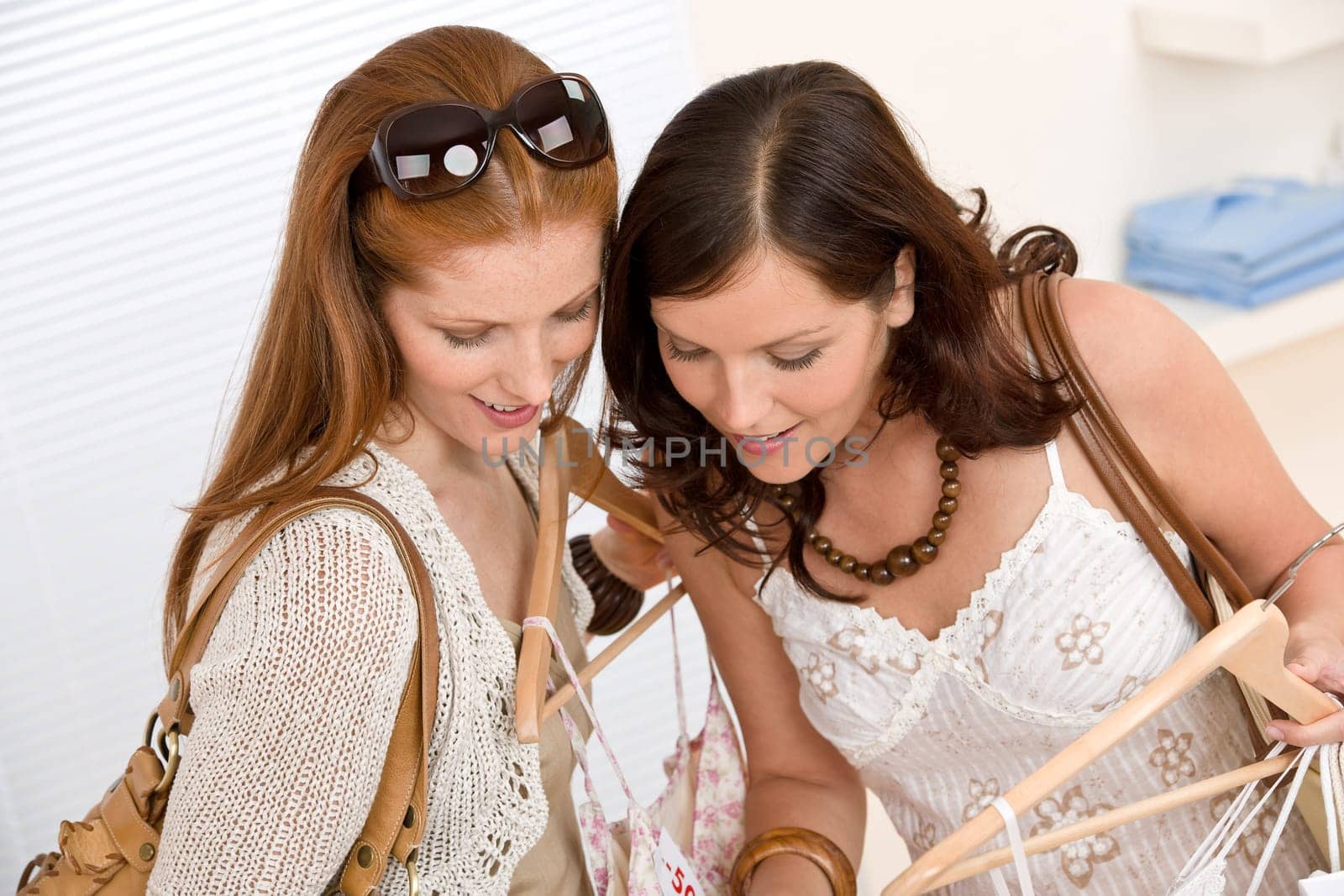 Fashion shopping - Two Happy woman choose sale clothes