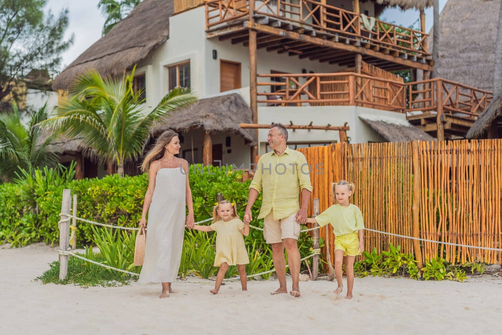 A joyful family, two girls, dad, and a pregnant mom, bask in tropical beach bliss, celebrating a radiant pregnancy amidst paradise by galitskaya