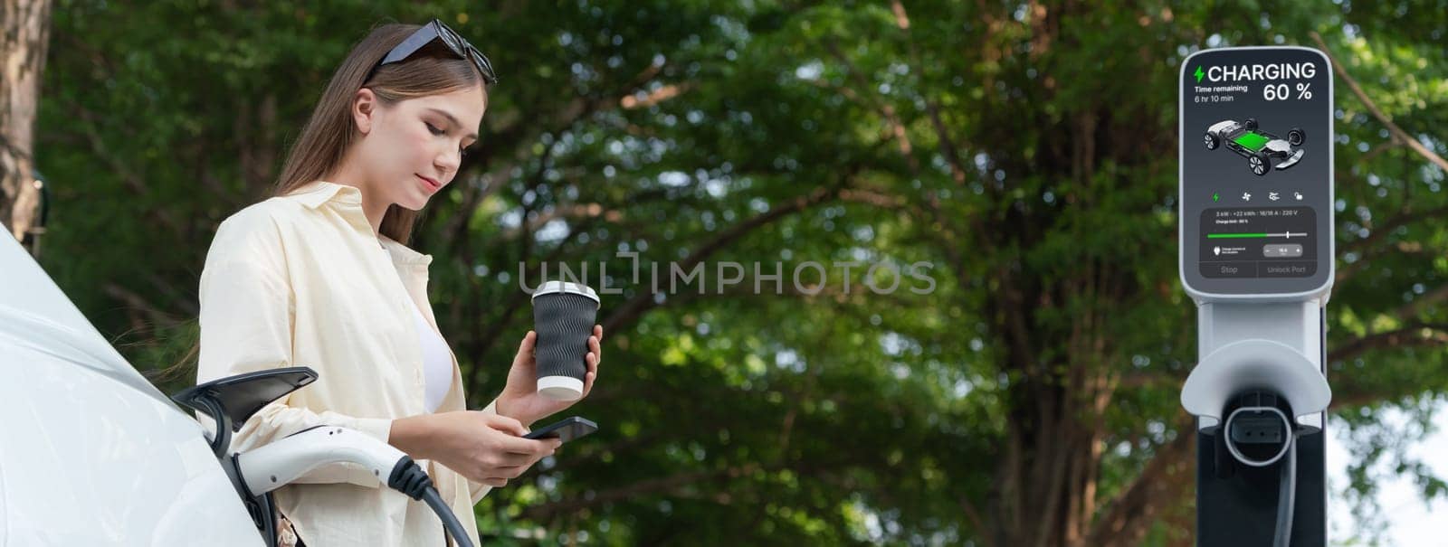 Young woman with coffee and sustainable urban commute by EV electric car recharging at outdoor cafe in springtime garden, green city sustainability and environmental friendly EV car.Panorama Expedient