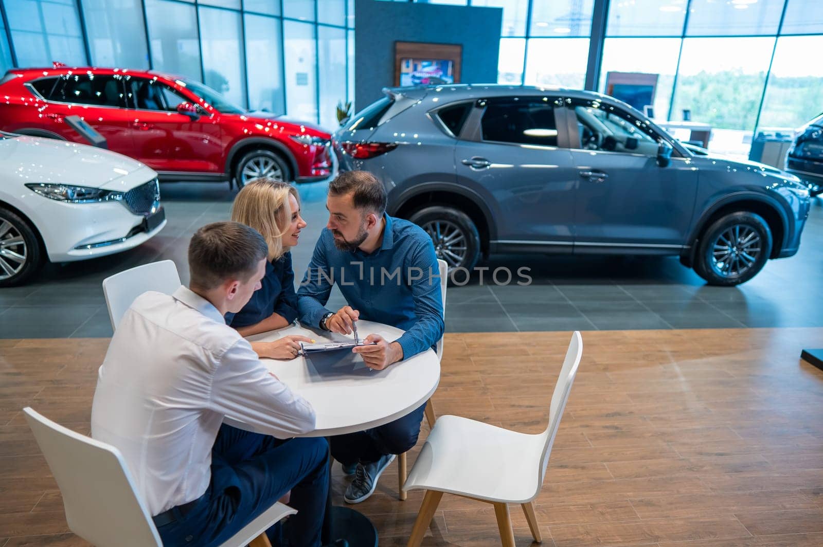 Happy caucasian couple signs a contract for the purchase of a car salon. by mrwed54