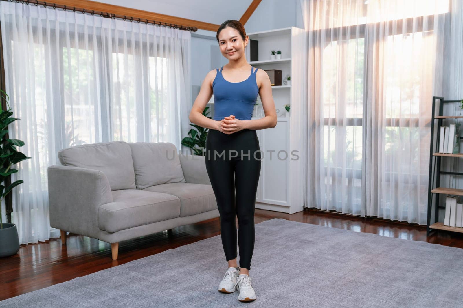 Full body asian woman in sportswear portrait, smiling and posing cheerful gesture. Home workout training with attractive girl engage in her pursuit of healthy lifestyle. Vigorous