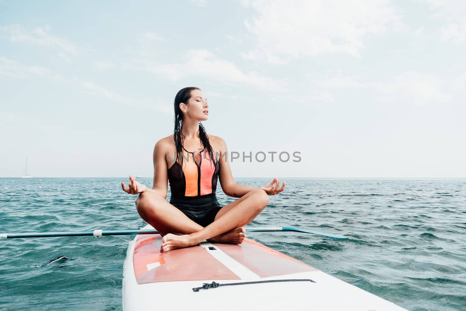 Woman sup yoga. Happy young sporty woman practising yoga pilates on paddle sup surfboard. Female stretching doing workout on sea water. Modern individual female outdoor summer sport activity. by panophotograph