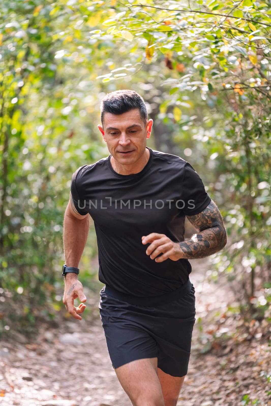 vertical portrait of a man practicing trail running in the forest, concept of sport in nature and healthy lifestyle, copy space for text