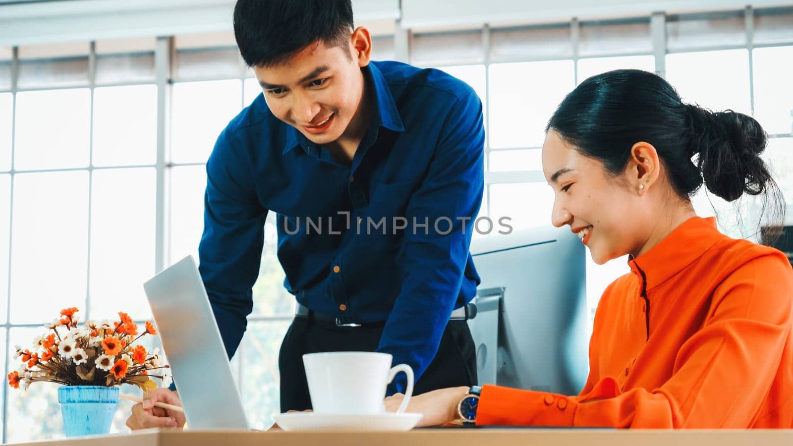 Two business people talk project strategy at office meeting room. Businessman discuss project planning with colleague at modern workplace while having conversation and advice on financial report. Jivy