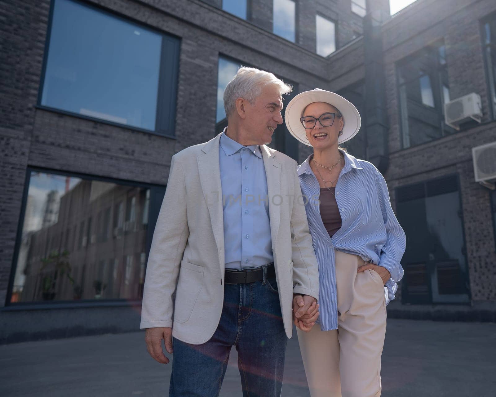 An elderly couple in love walks through the city