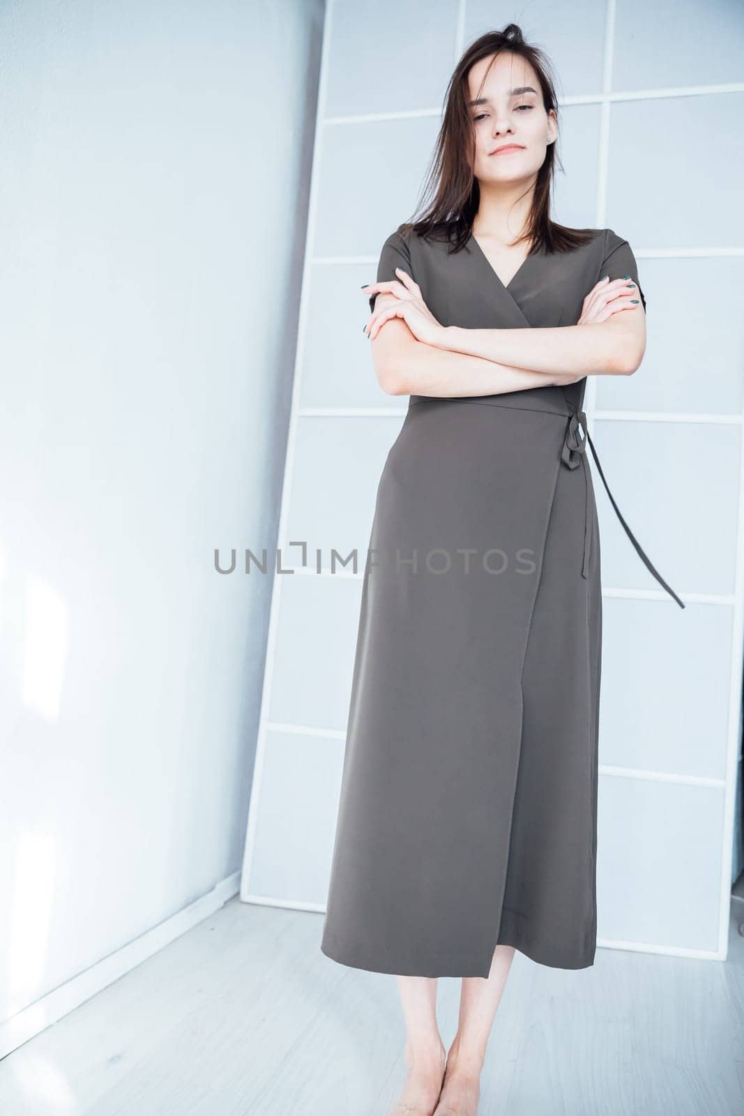 woman in a black dress stands in a bright room