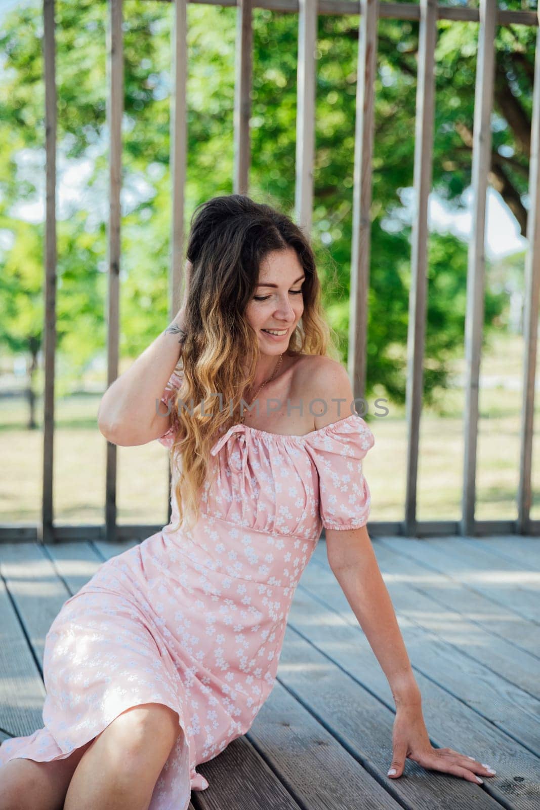 beautiful girl sitting on a wooden floor on the street in the park walk