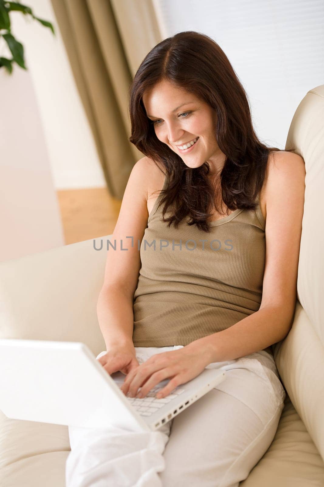 Young woman with laptop on sofa home