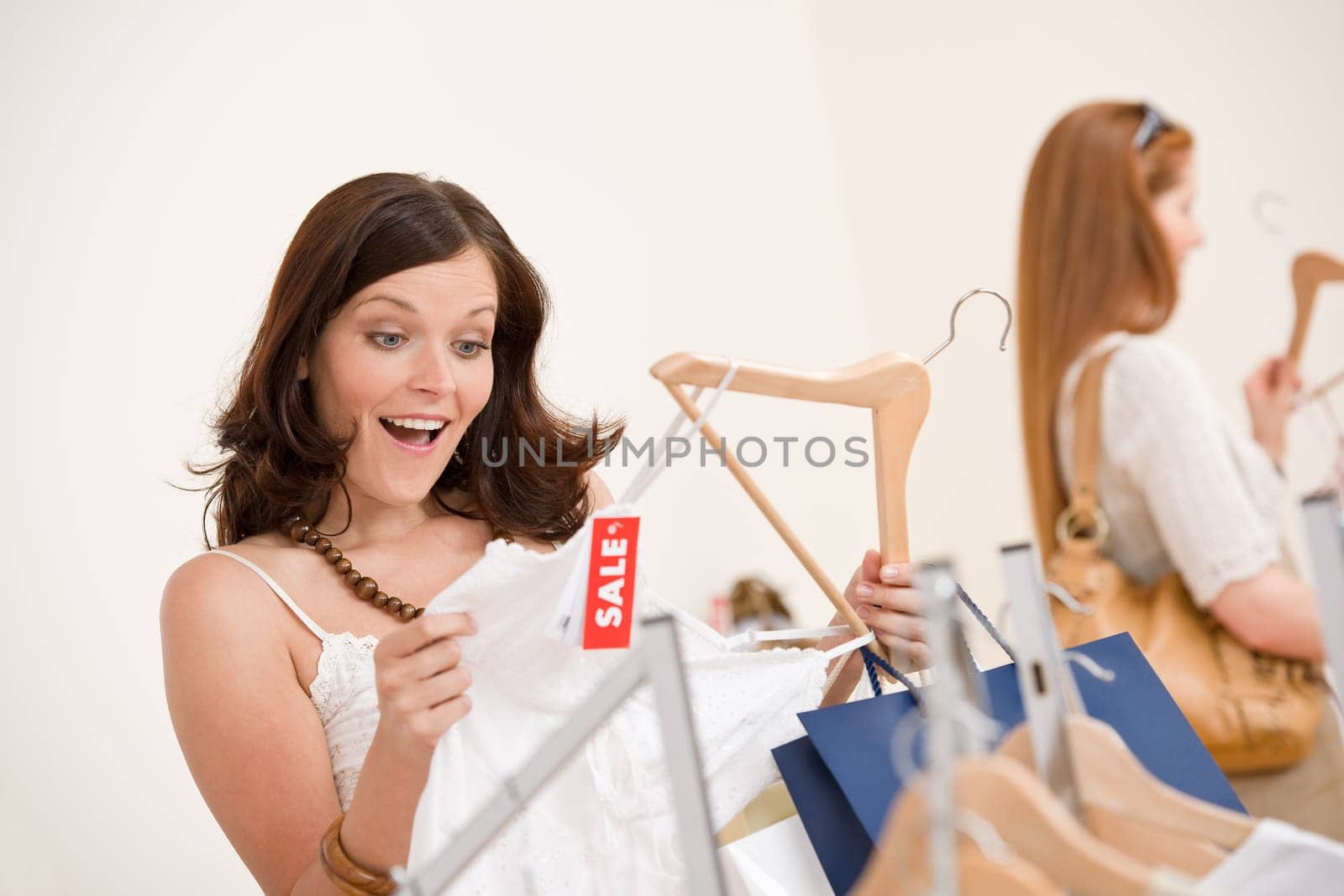 Fashion shopping - Two Happy woman choose sale clothes