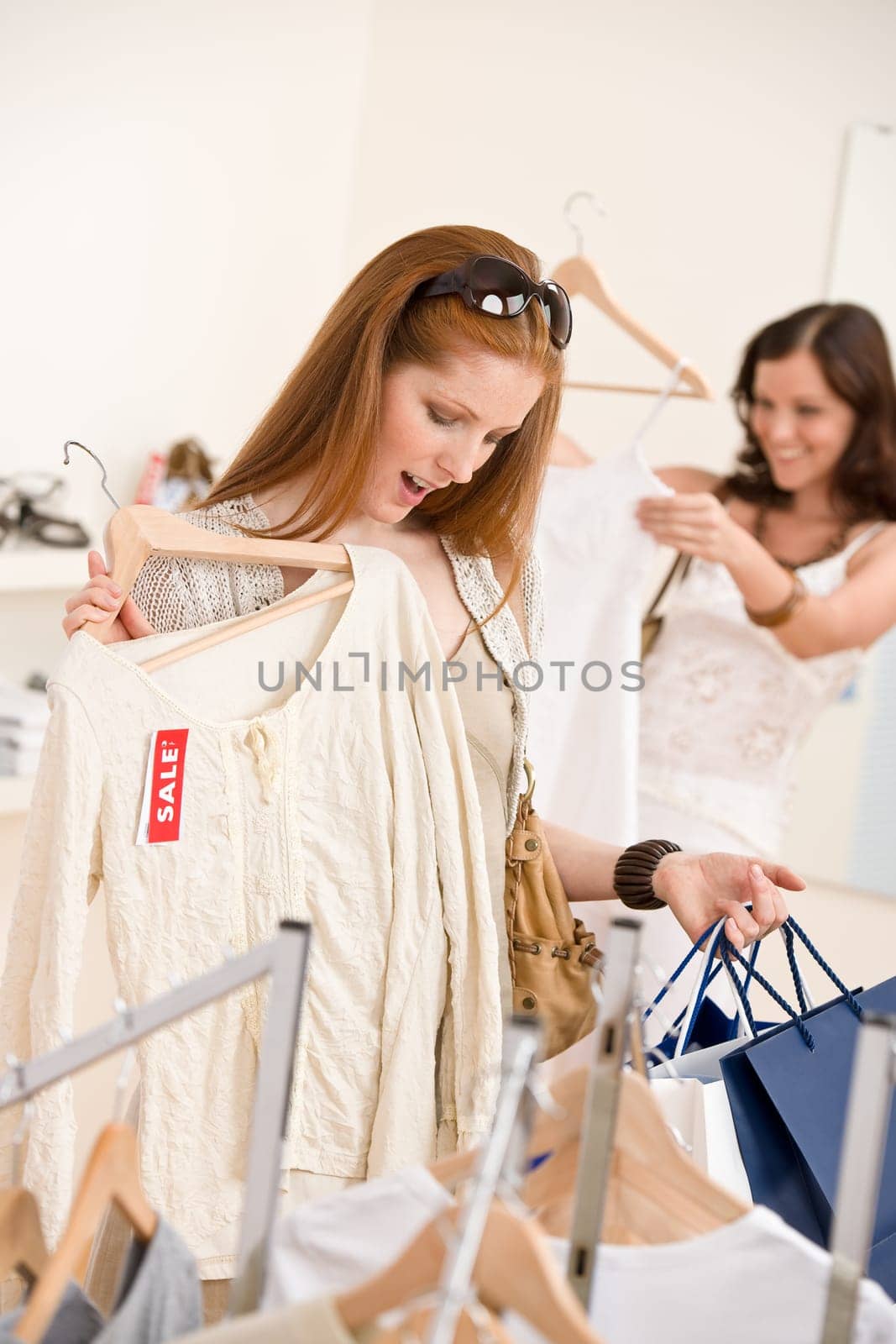 Fashion shopping - Two Happy woman choose sale clothes