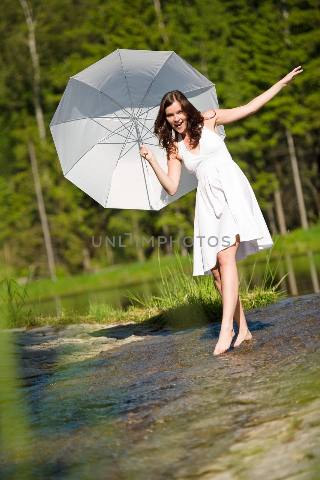 Happy romantic woman with parasol in sunlight