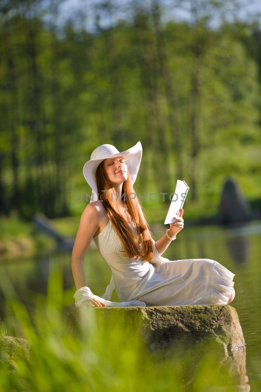 Long red hair romantic woman relax by lake with book