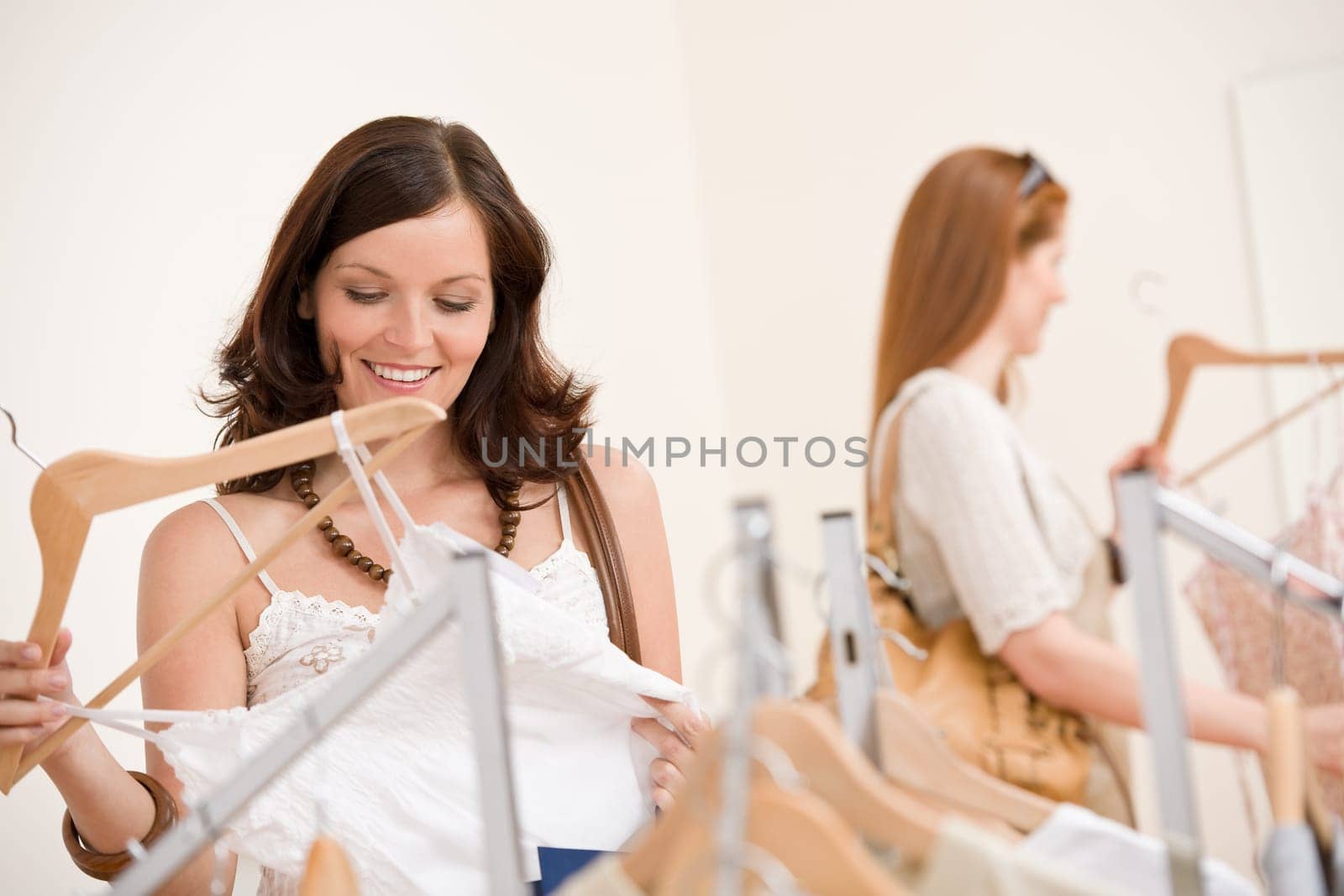 Fashion shopping - Two Happy woman choose sale clothes