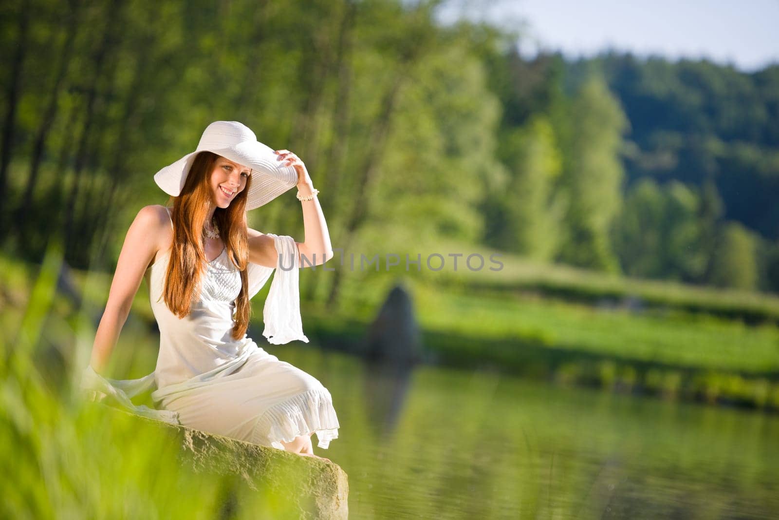 Long red hair romantic woman relax by lake with book
