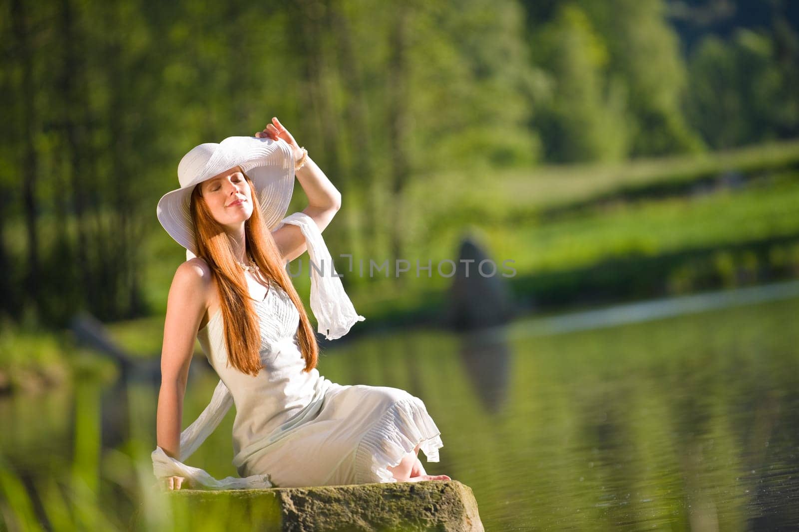 Long red hair romantic woman relax by lake with book