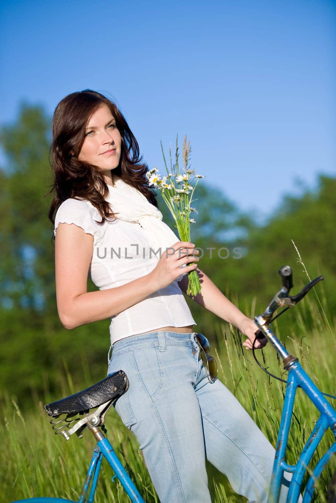 Woman with old-fashioned bike in meadow
