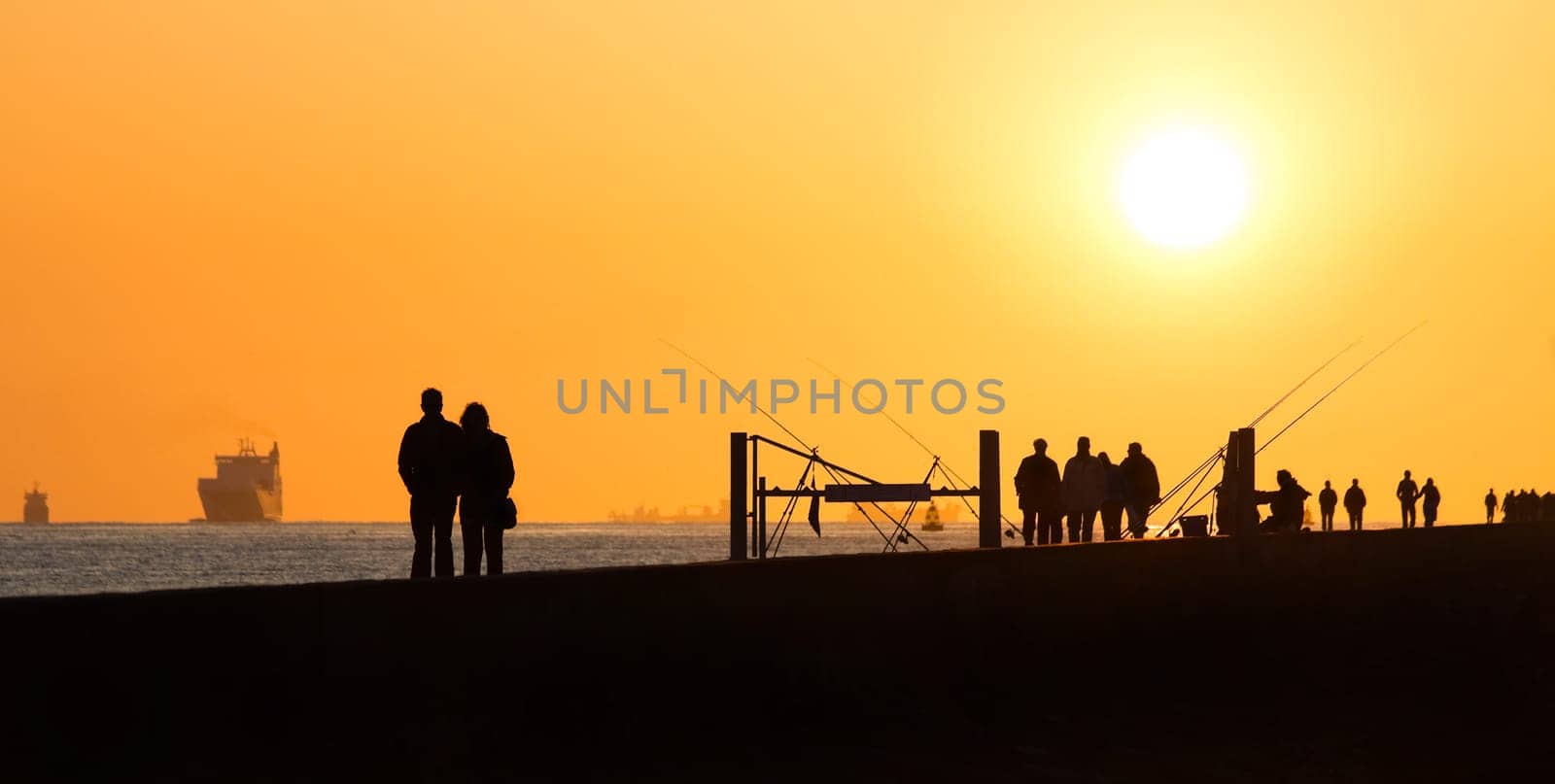 Pier with people fishing and walking