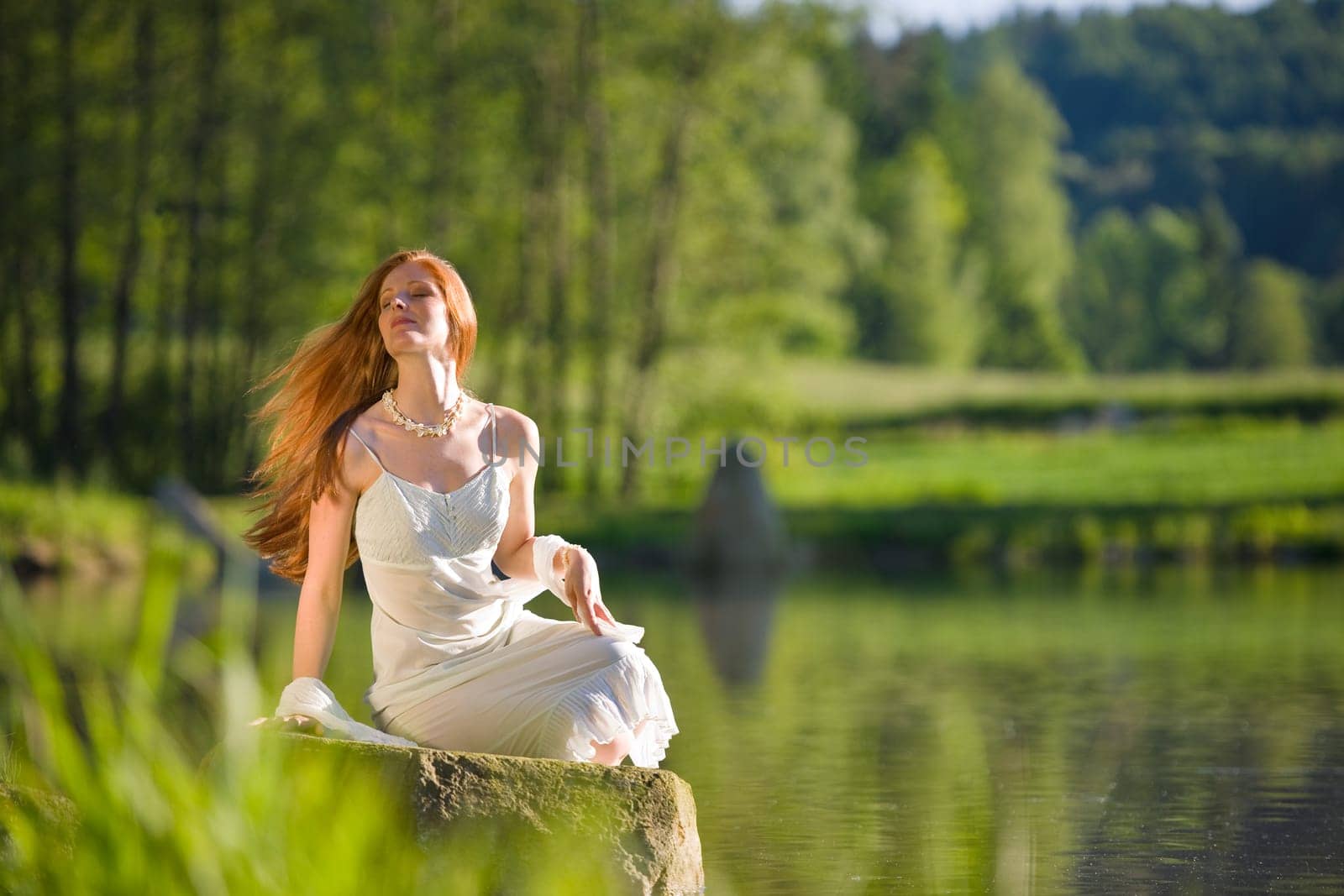 Long red hair romantic woman by lake