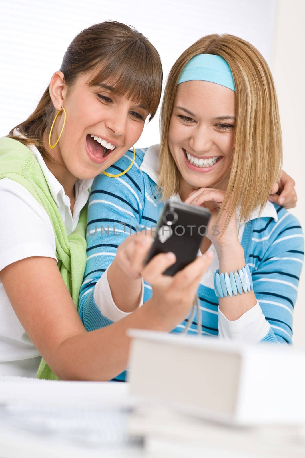 Two young cheerful woman with camera
