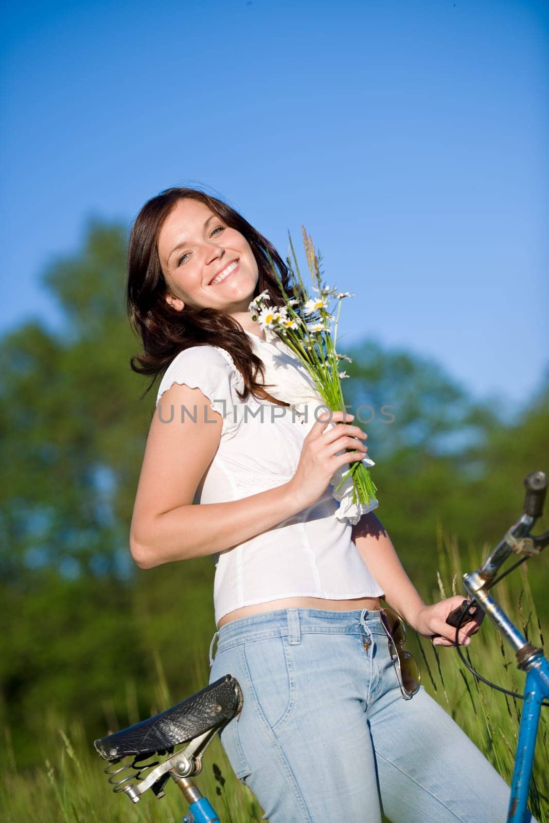 Woman with old-fashioned bike in meadow