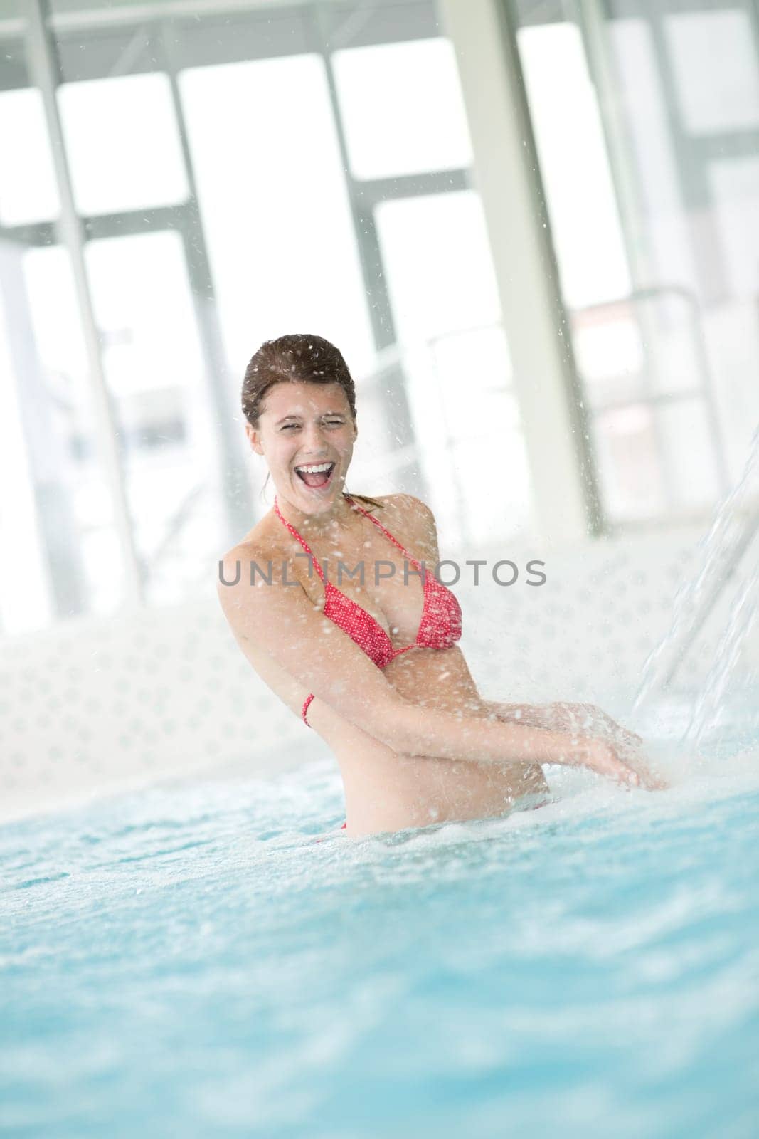 Swimming pool - happy woman under water stream