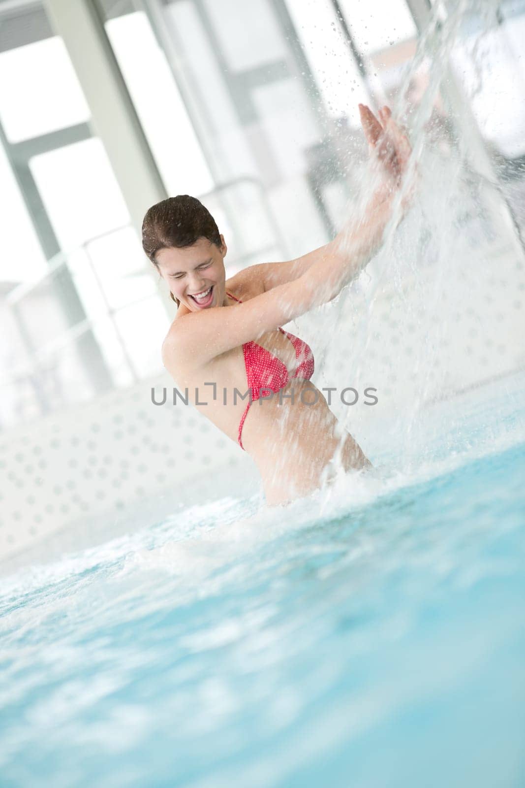 Swimming pool - happy woman under water stream