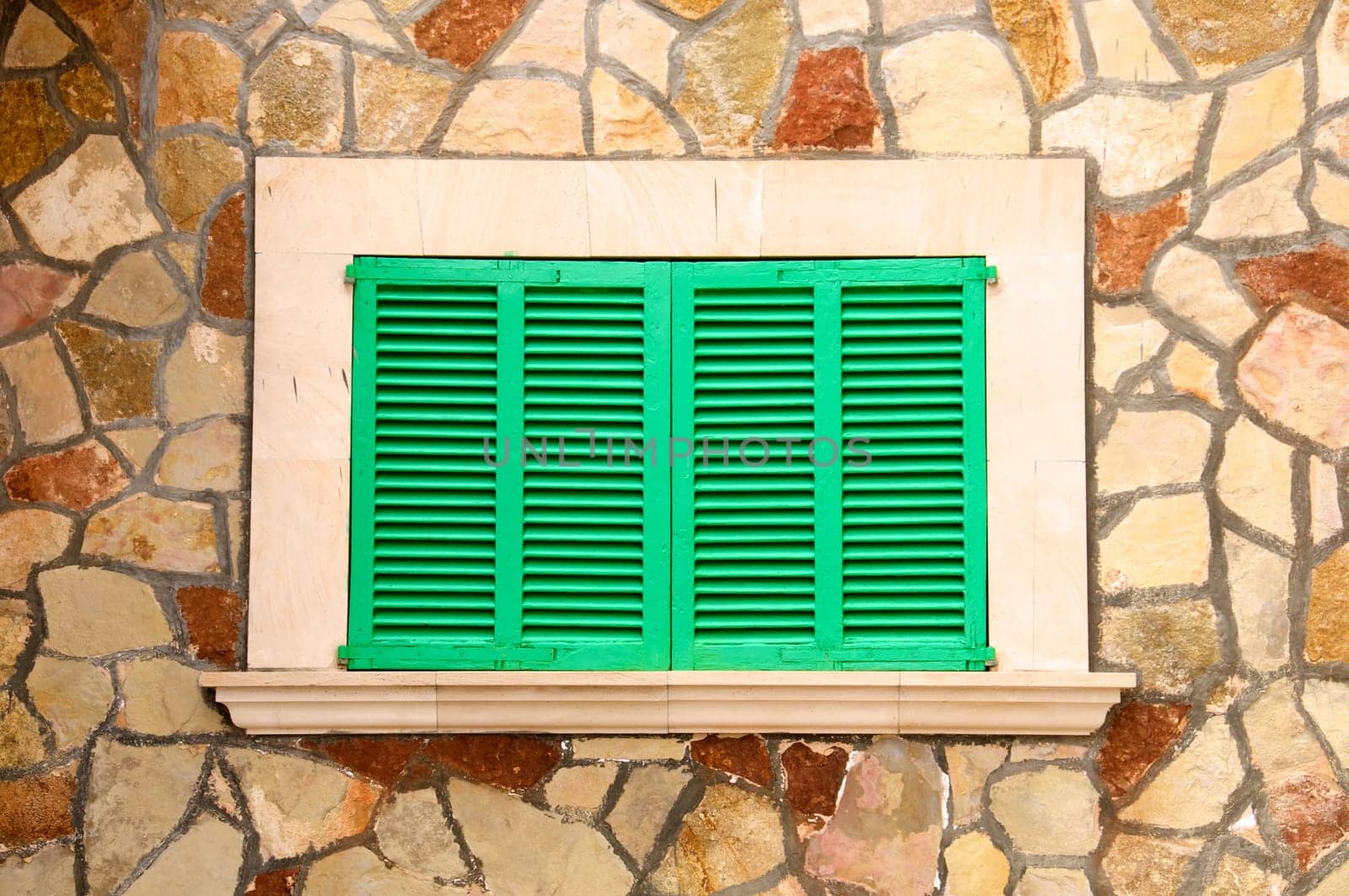 Green shutters in a stone wall