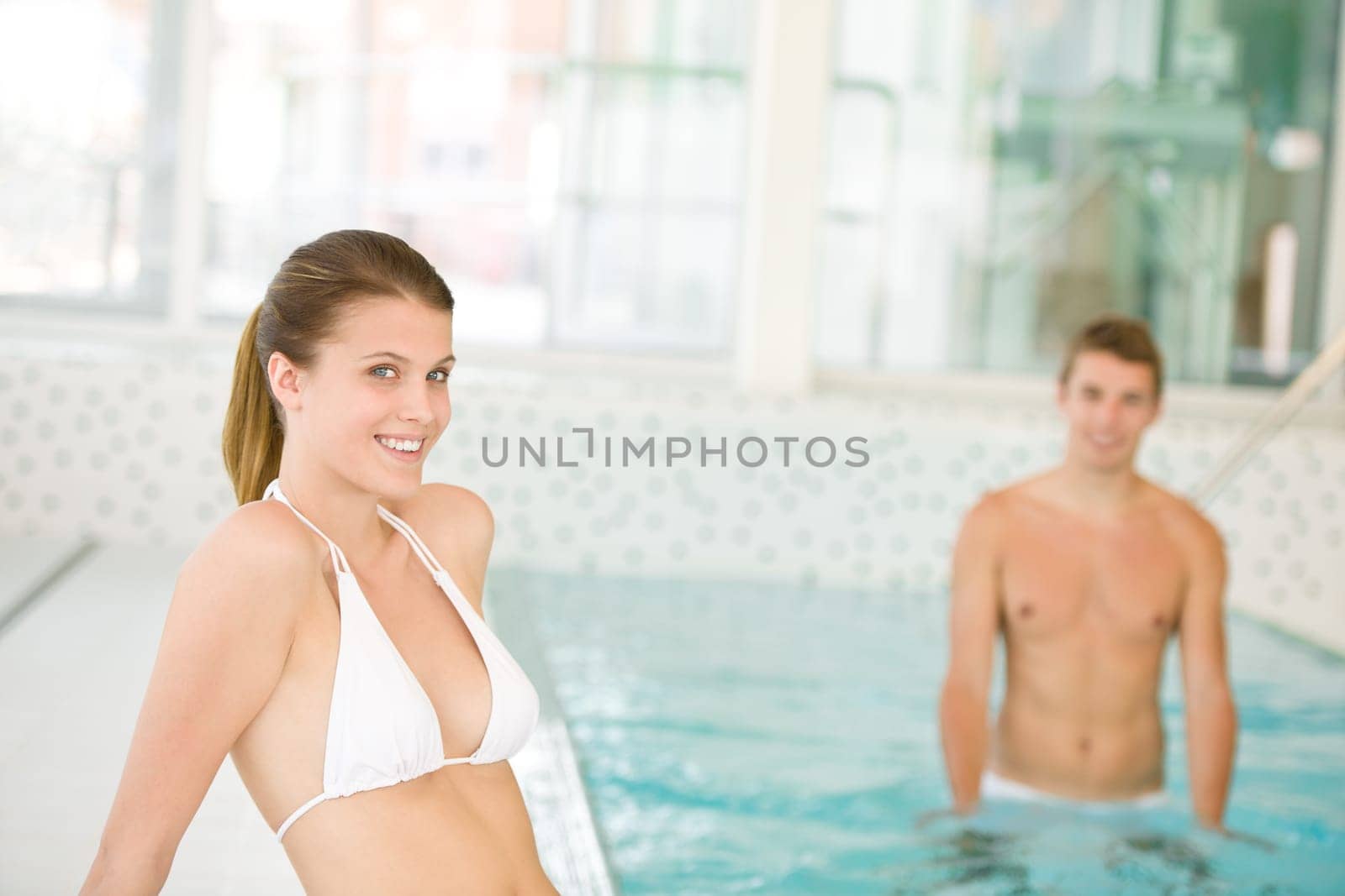 Swimming pool - young sportive couple relax