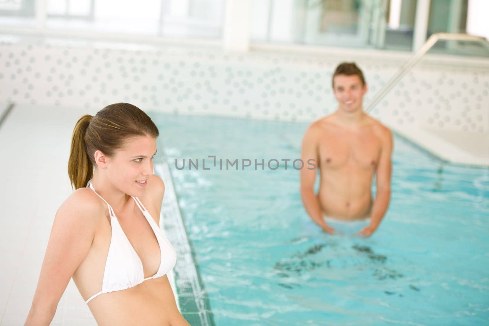 Swimming pool - young sportive couple relax
