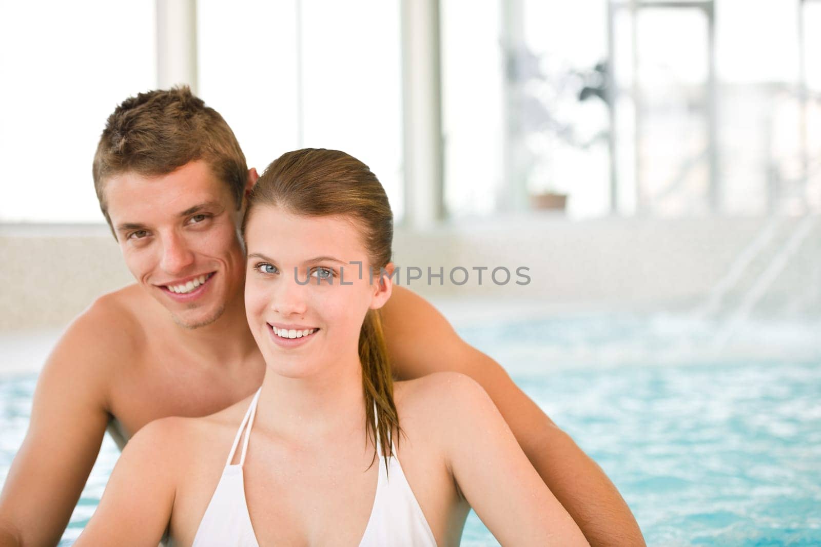 Swimming pool - young cheerful couple have fun