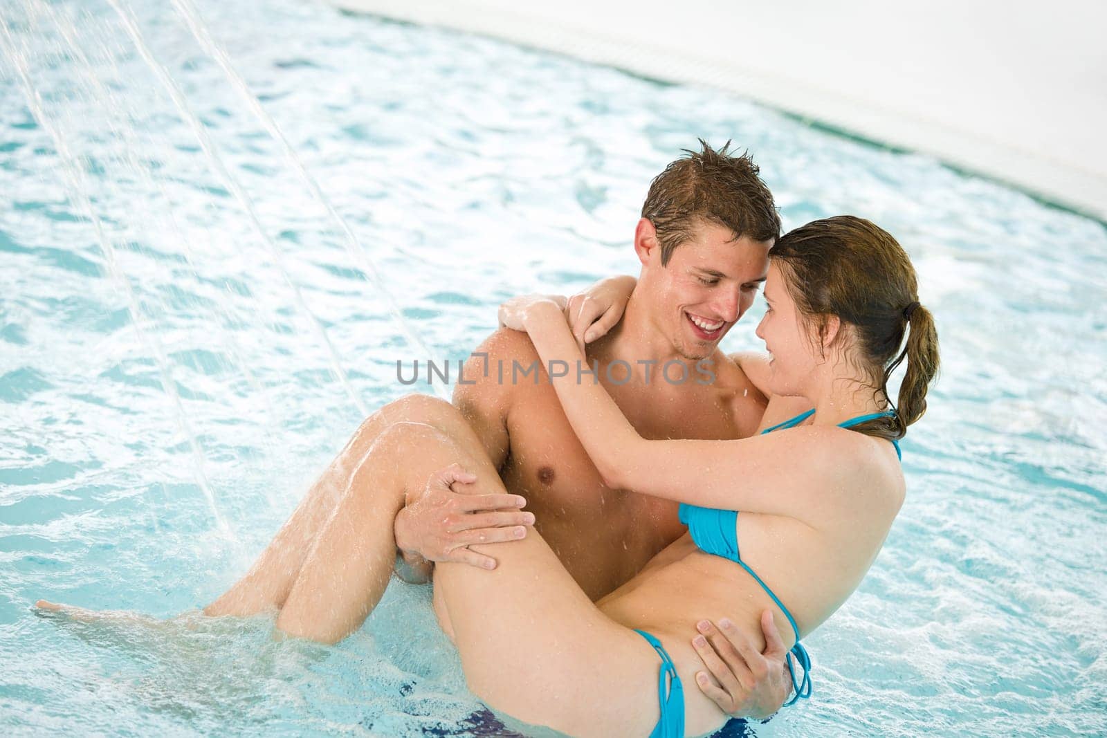 Swimming pool - young loving couple have fun