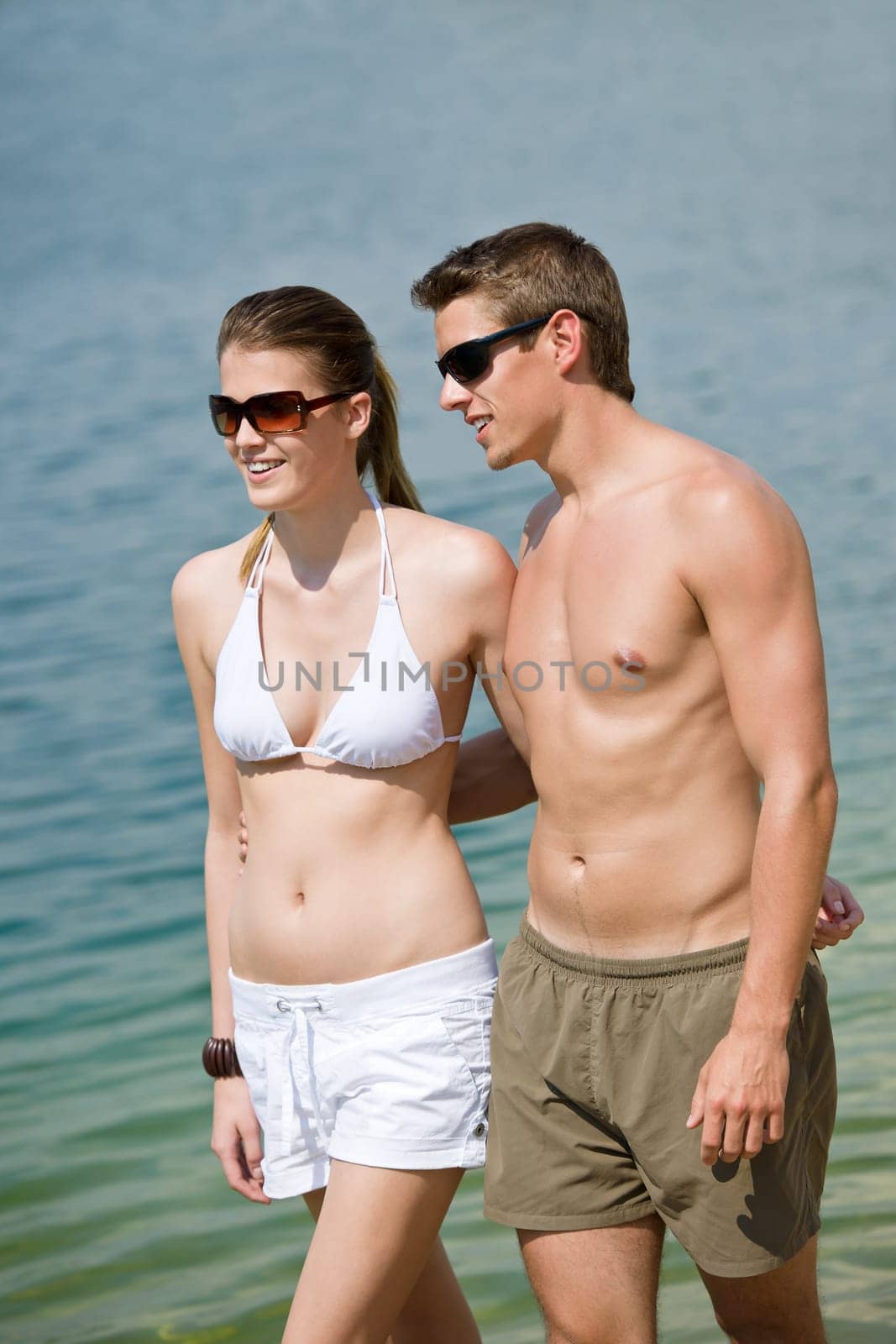 Happy couple in swimwear walk in lake