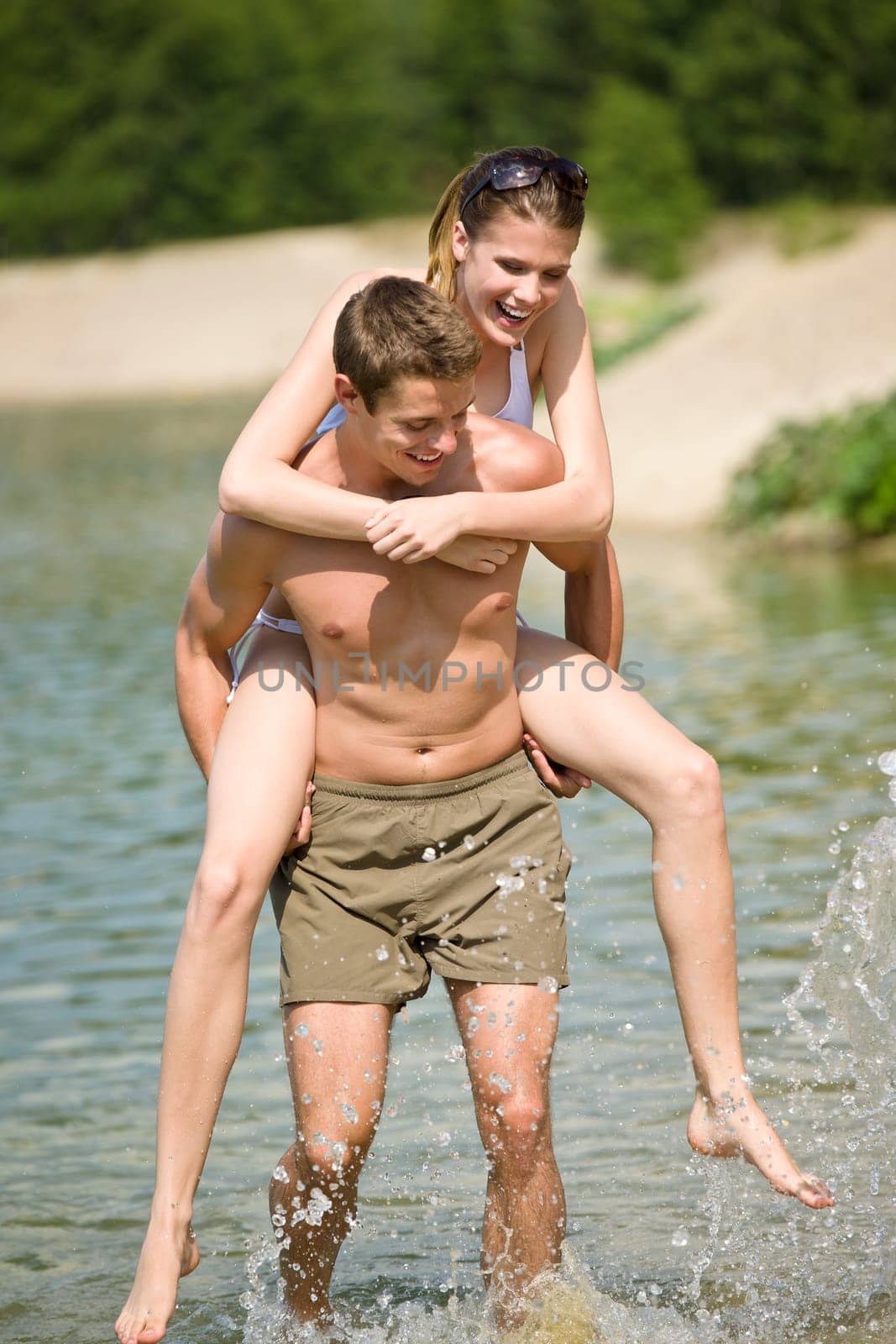 Piggyback - happy couple enjoy sun in nature