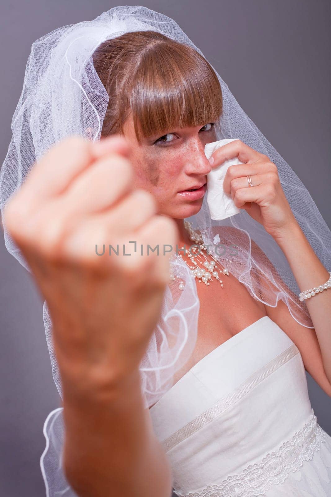crying bride showing her fist