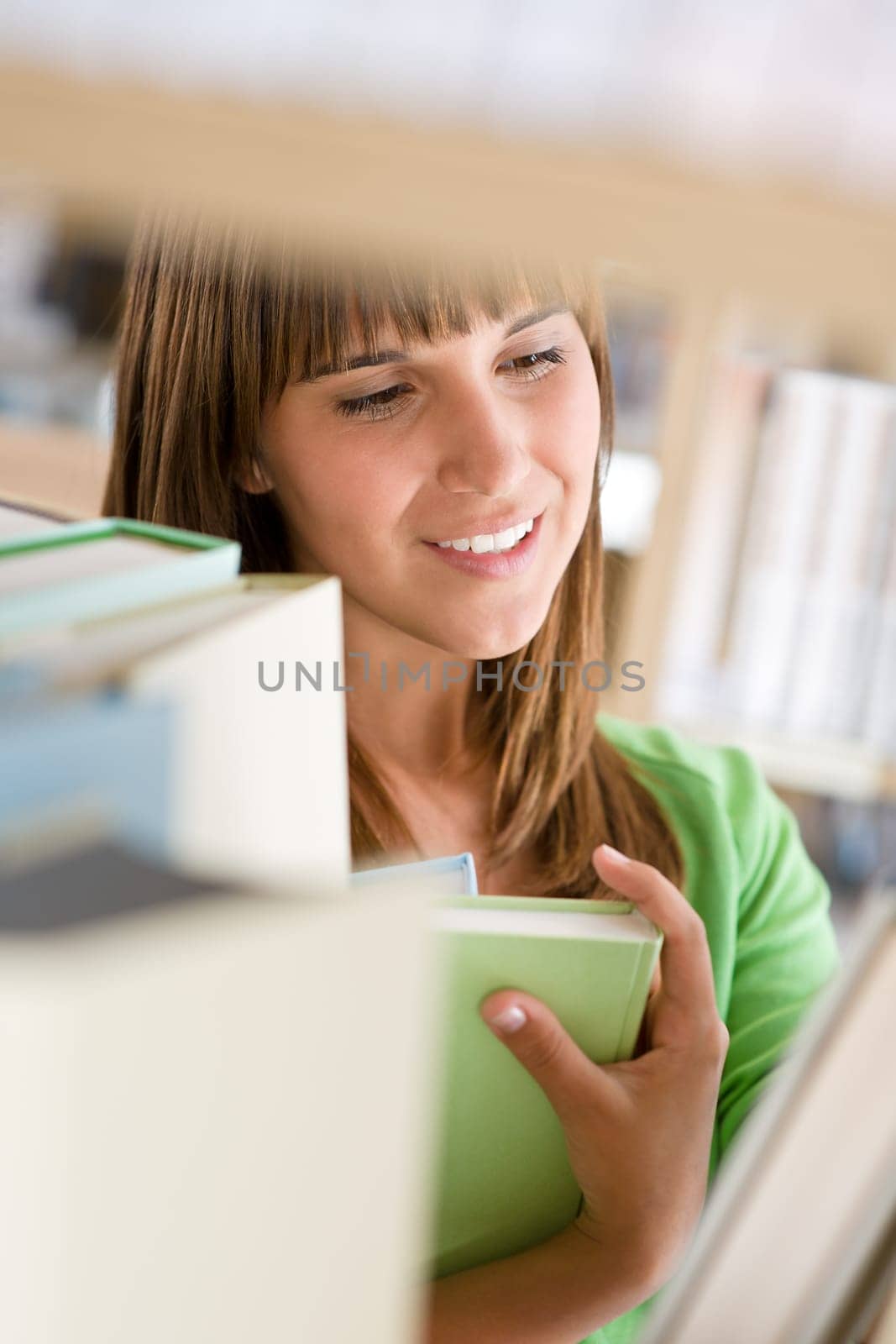 Student in library - cheerful woman stand by bookshelf