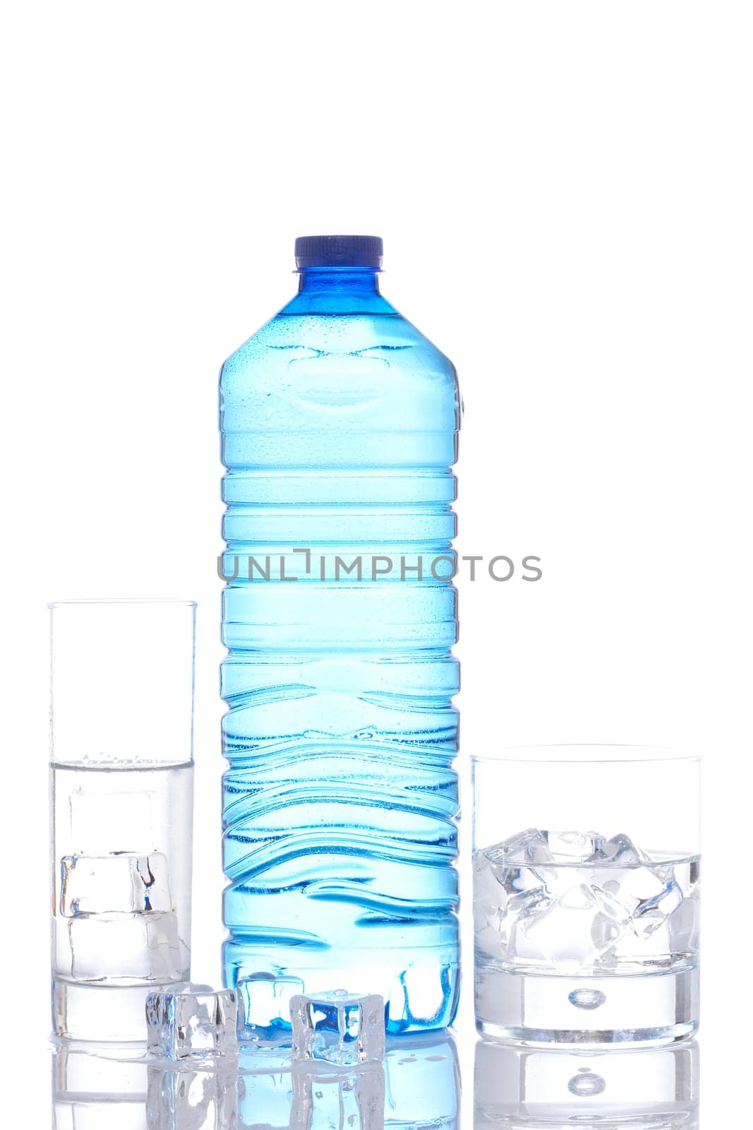 Bottle and glasses of mineral water with ice cubes