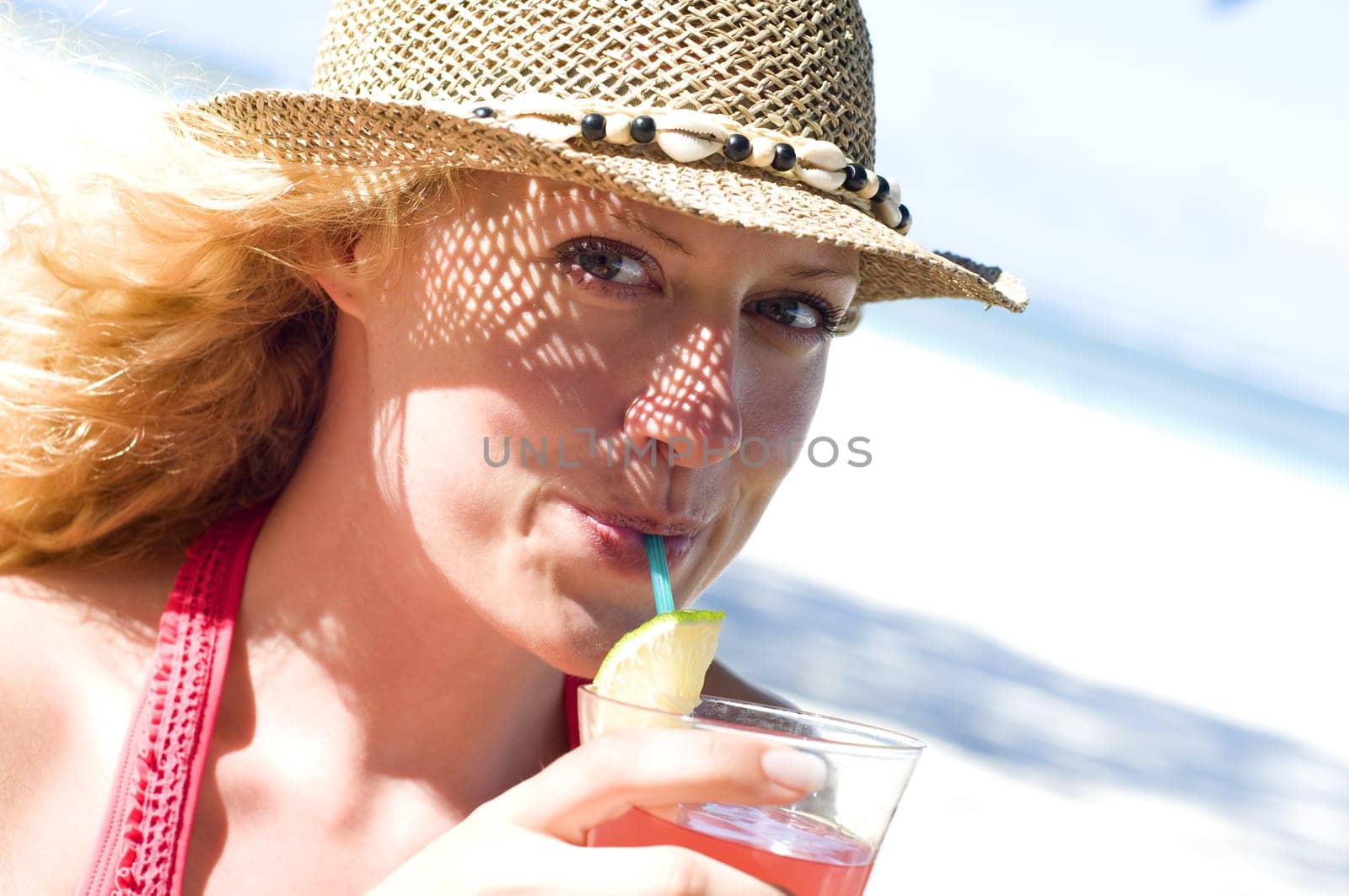 Woman with cocktail on the beach