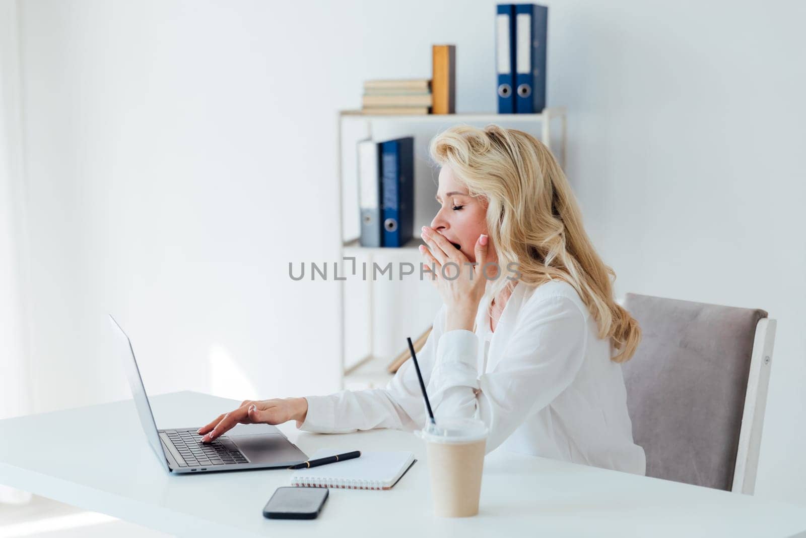 online communication a woman yawns at a laptop remote work a conversation on skype internet is boring