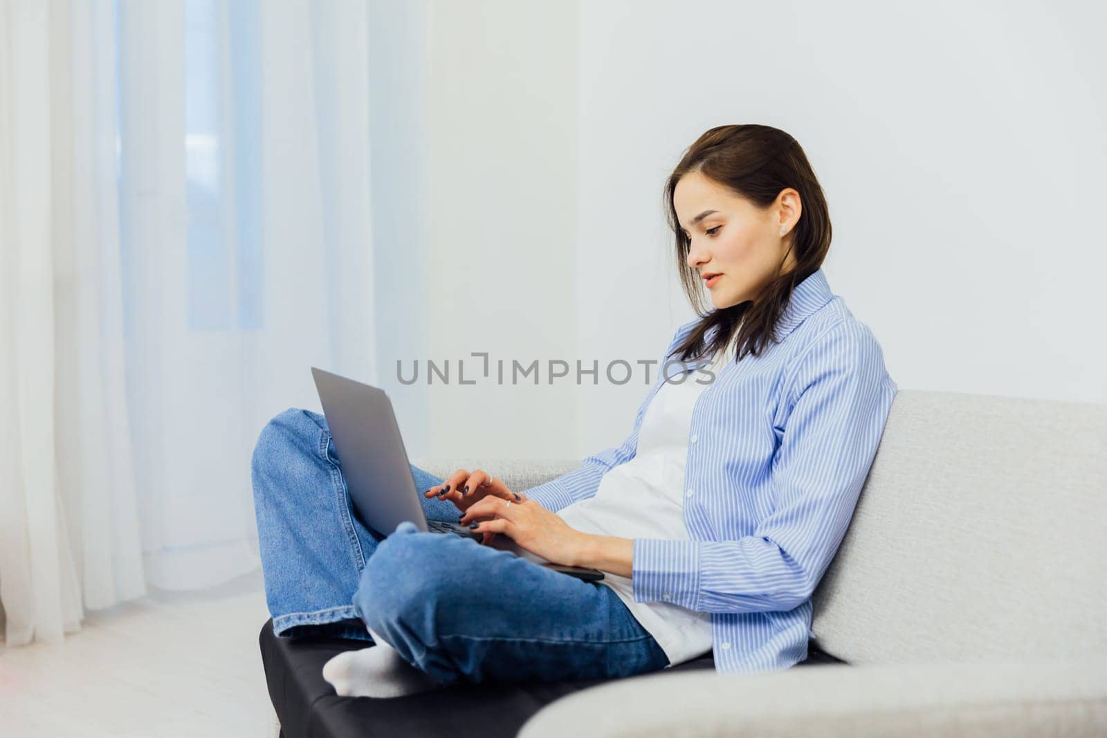 a woman works at a laptop computer in the room remote work conversation on skype internet online communication
