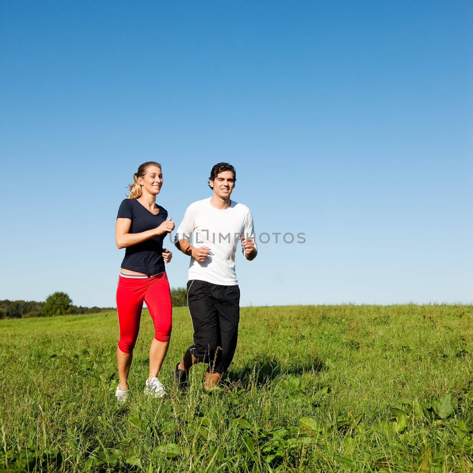 Sports couple jogging in summer