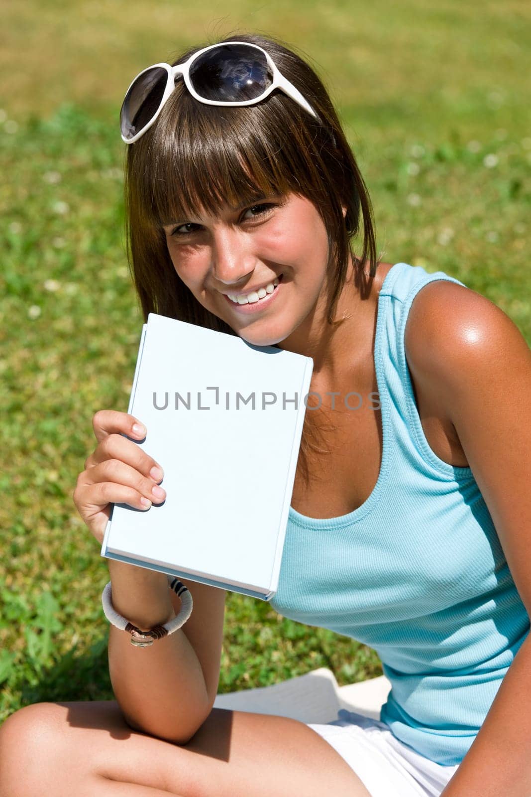 Smiling young woman read book in park