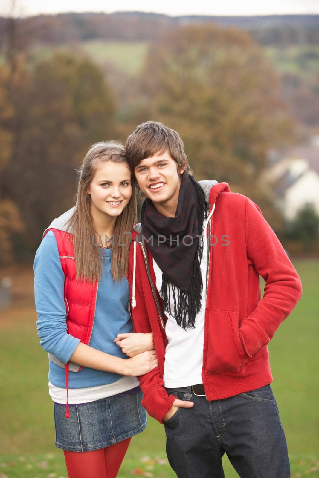 Romantic Teenage Couple Walking Through Autumn Landscape