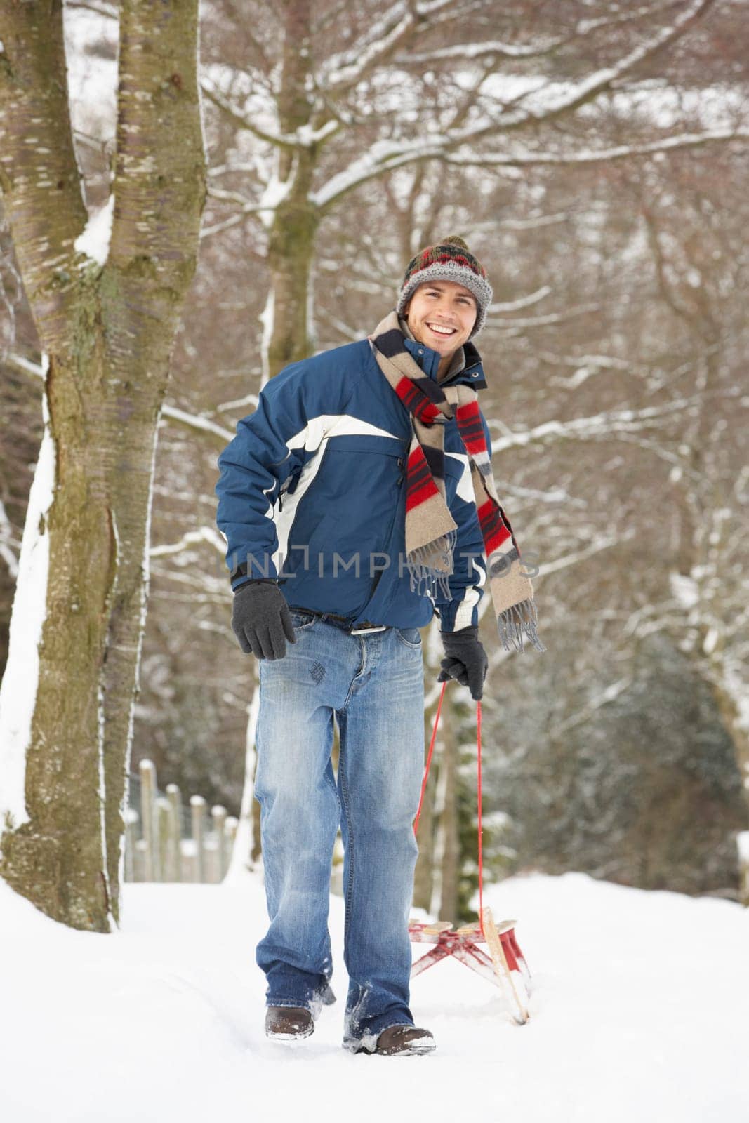 Man Pulling Sledge Through Winter Landscape